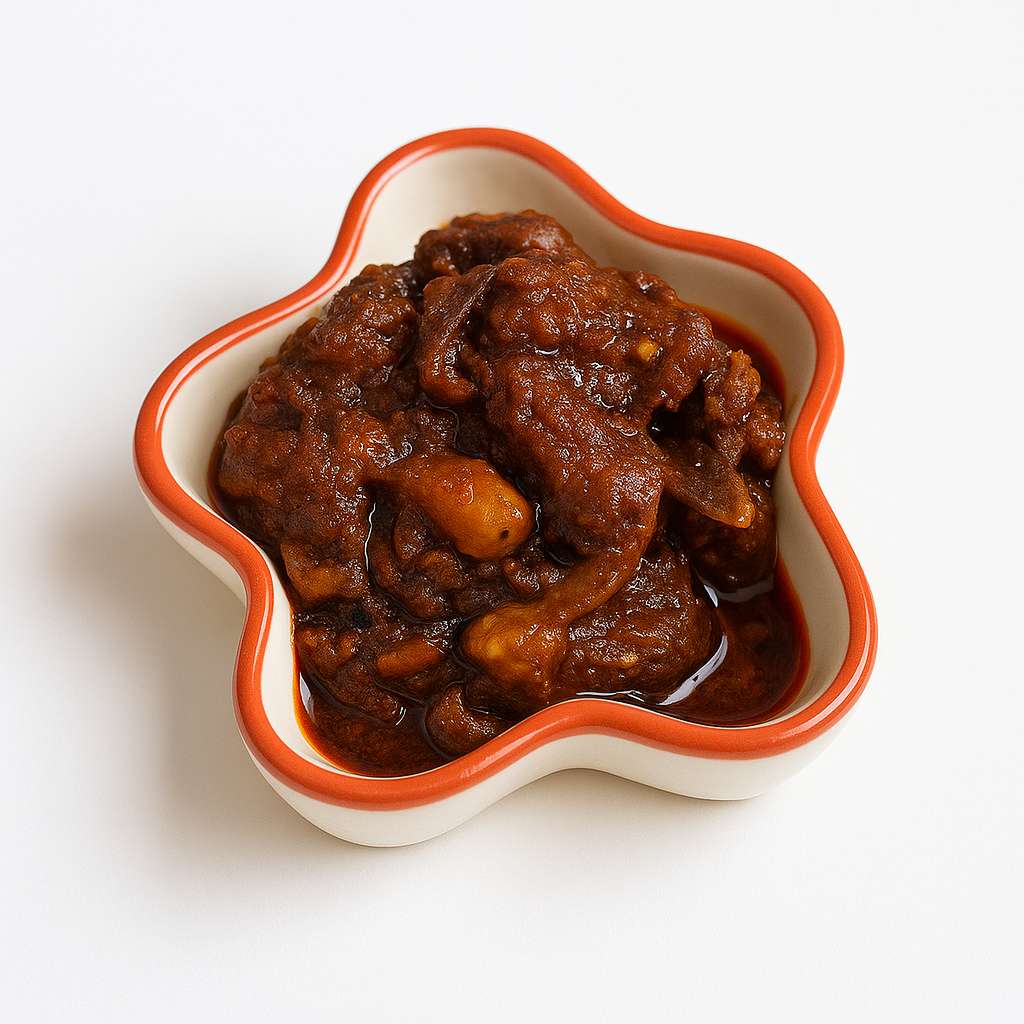 Buffalo Pickle in a bowl — tender buffalo chunks in smoky roasted Kerala spices